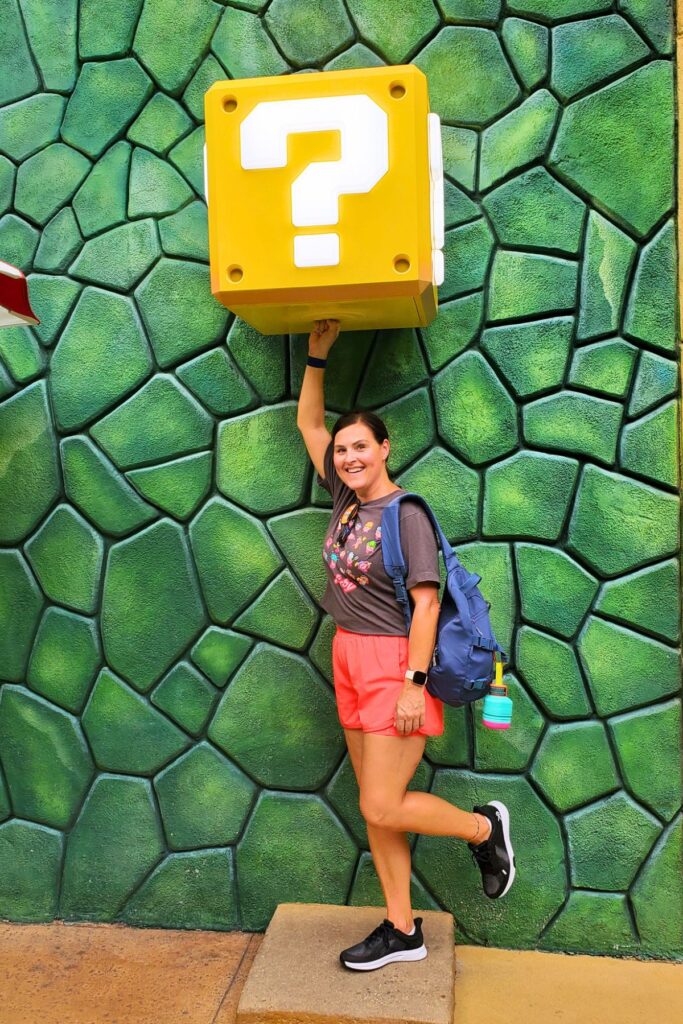 girl touching a Mario question mark block at Epic Universe park