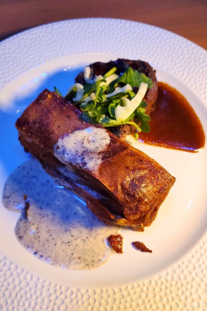 Filet mignon on a white plate with steak sauce