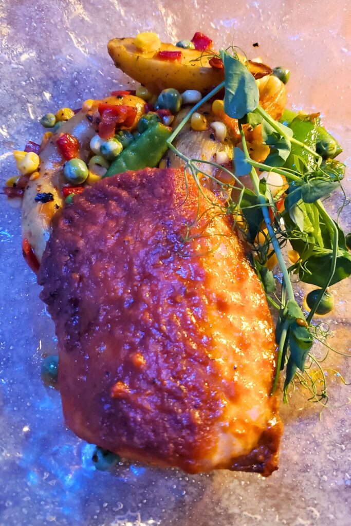 baked salmon with mixed vegetables on a clear plate