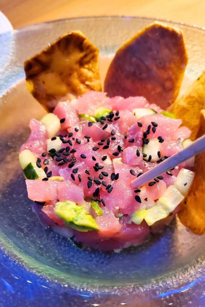watermelon raw tuna on a plate with poppy seeds on top and cucumber pieces